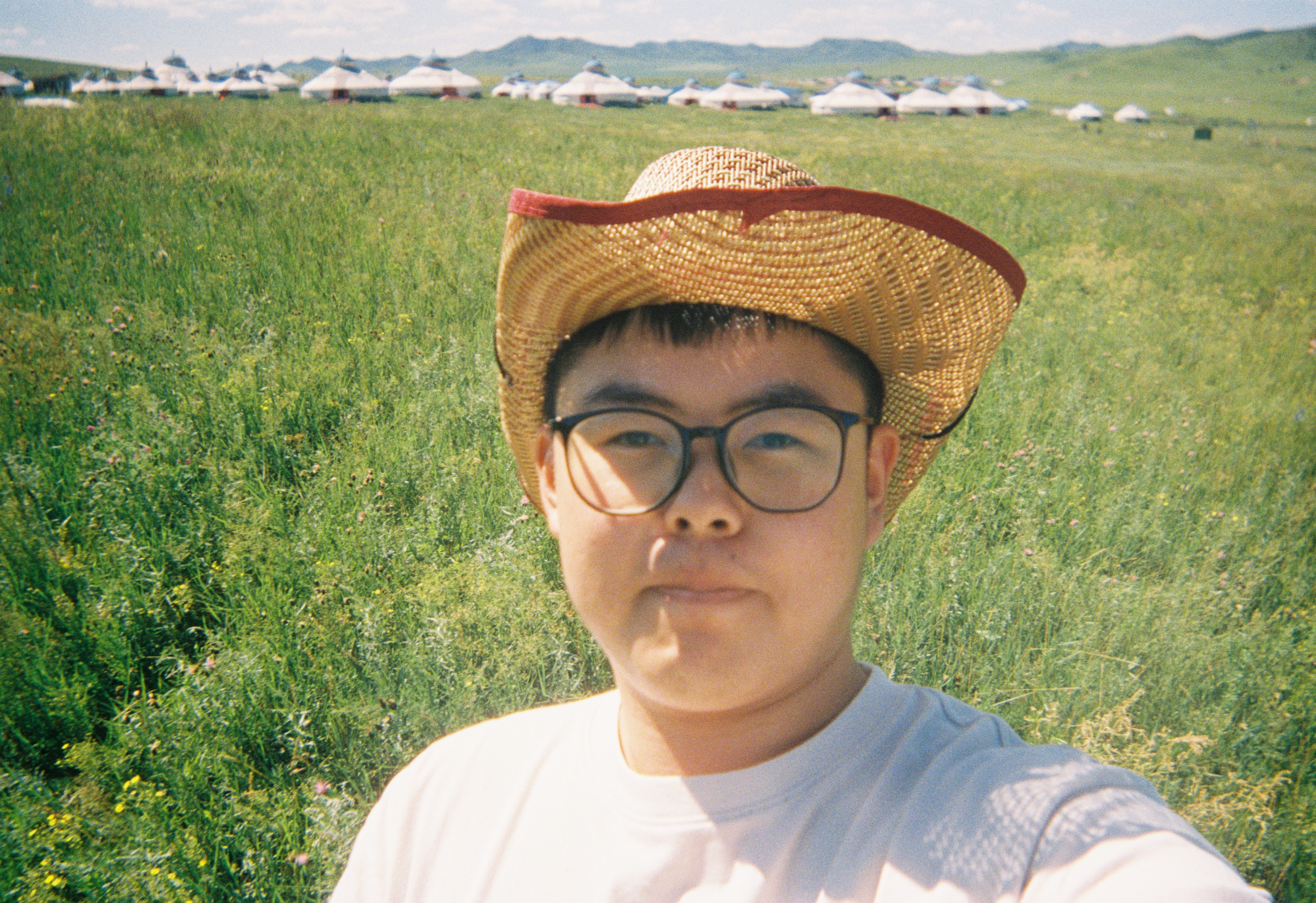 Xihao Zhang in a grassland setting for the SuperFarmer project